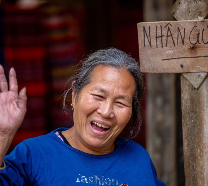 Vietnamese woman waving and smiling